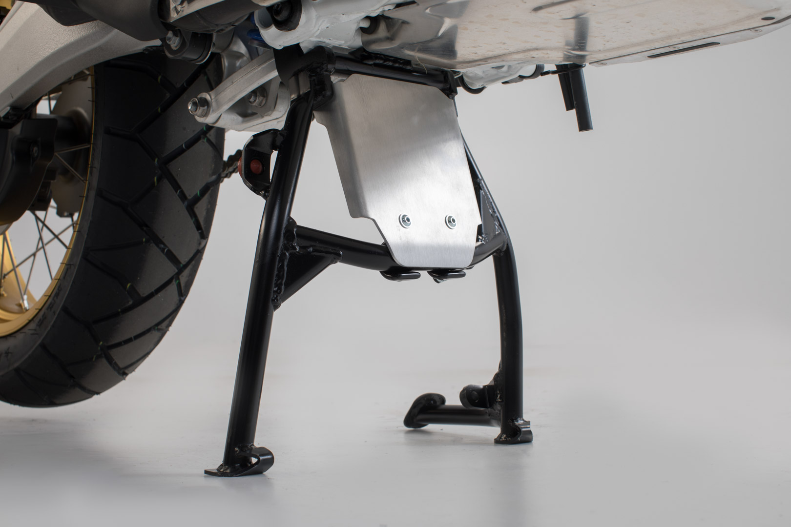 Silver aluminum engine guard extension mounted on a black centerstand, designed for Honda CRF1000L (2015-) and CRF1100L (2019-), showcasing a sturdy and protective design.