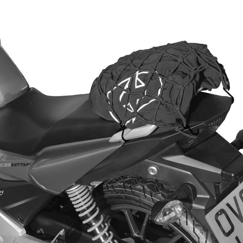 Black Oxford Travel cargo net, measuring 43x43 cm, features a durable elastic design, securely fitted over a motorcycle seat with visible hooks and a textured surface.