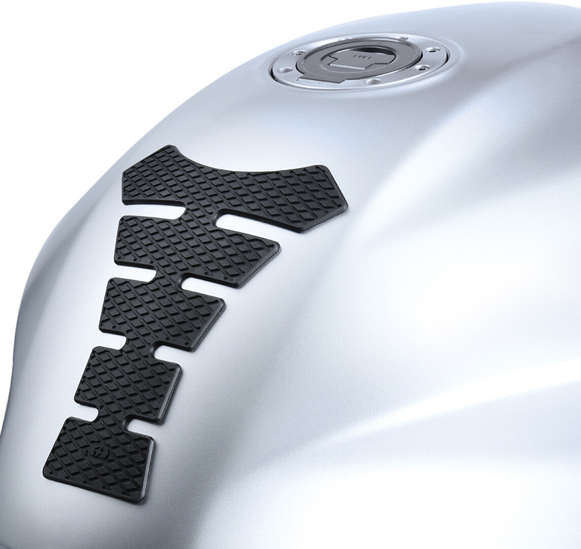 Black rubber tank pad with a textured surface, featuring an angular design, positioned on a silver motorcycle tank near the fuel cap.