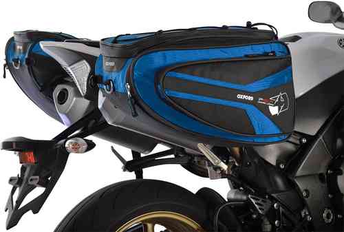 Oxford P50R motorcycle panniers in blue and black, made of durable material, featuring zippered compartments and a sleek design, mounted on a motorcycle's rear.