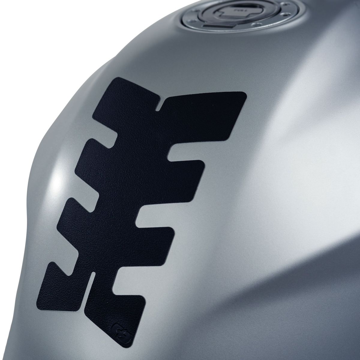 Low profile tank protector in black rubber with a textured design, featuring a prominent scarab pattern, set against a sleek silver background.