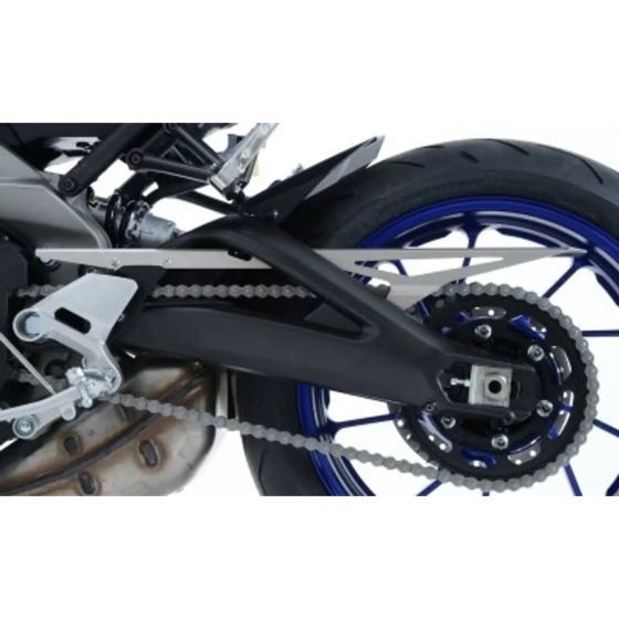 Aluminium chain guard in silver, featuring a sleek design, mounted on a motorcycle, with a black swingarm and blue wheels visible in the background.
