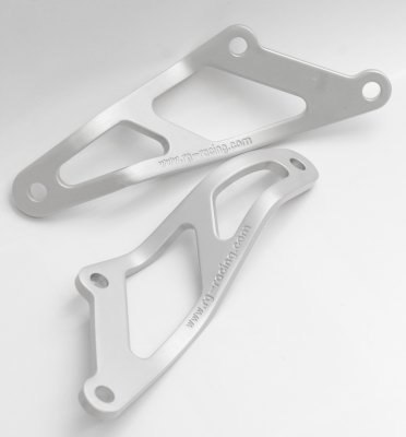 Silver aluminum motorcycle exhaust hanger with a sleek design, featuring cut-out shapes and two mounting holes for secure installation.
