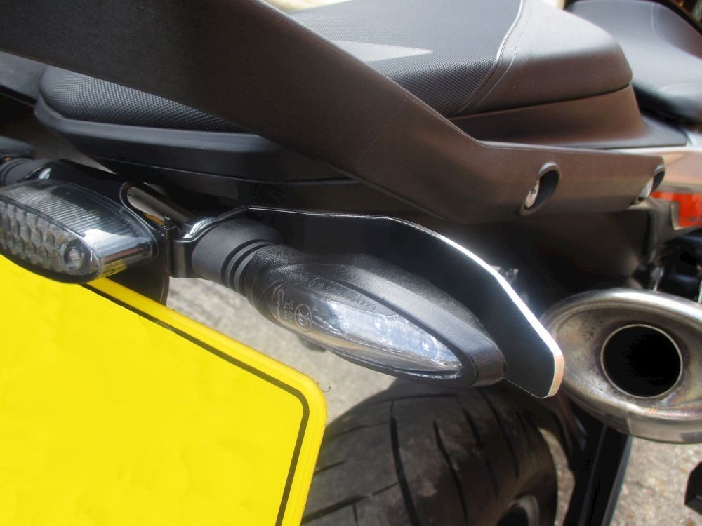Black heat shield for KTM 790 Duke indicators, made of durable material, featuring a sleek design that protects the turn signal from heat and damage, mounted near the rear of the bike.