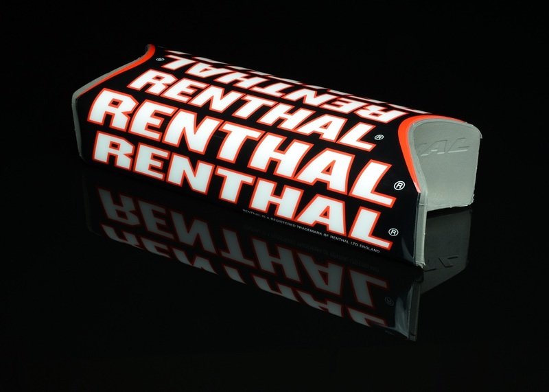 Black handlebar pad with bold white and red "RENTHAL" branding, featuring a sleek design and a durable material, reflecting light on a dark surface.