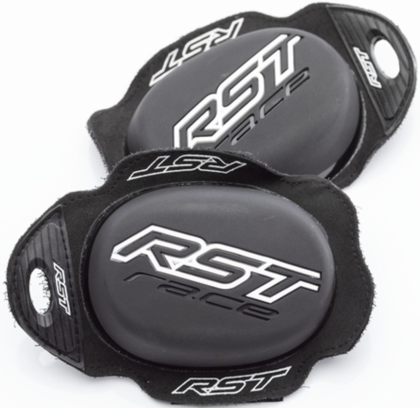 Matt-black RST Race knee sliders featuring a sleek oval design, made of durable material, with a prominent silver RST logo on the surface and textured edges for grip.