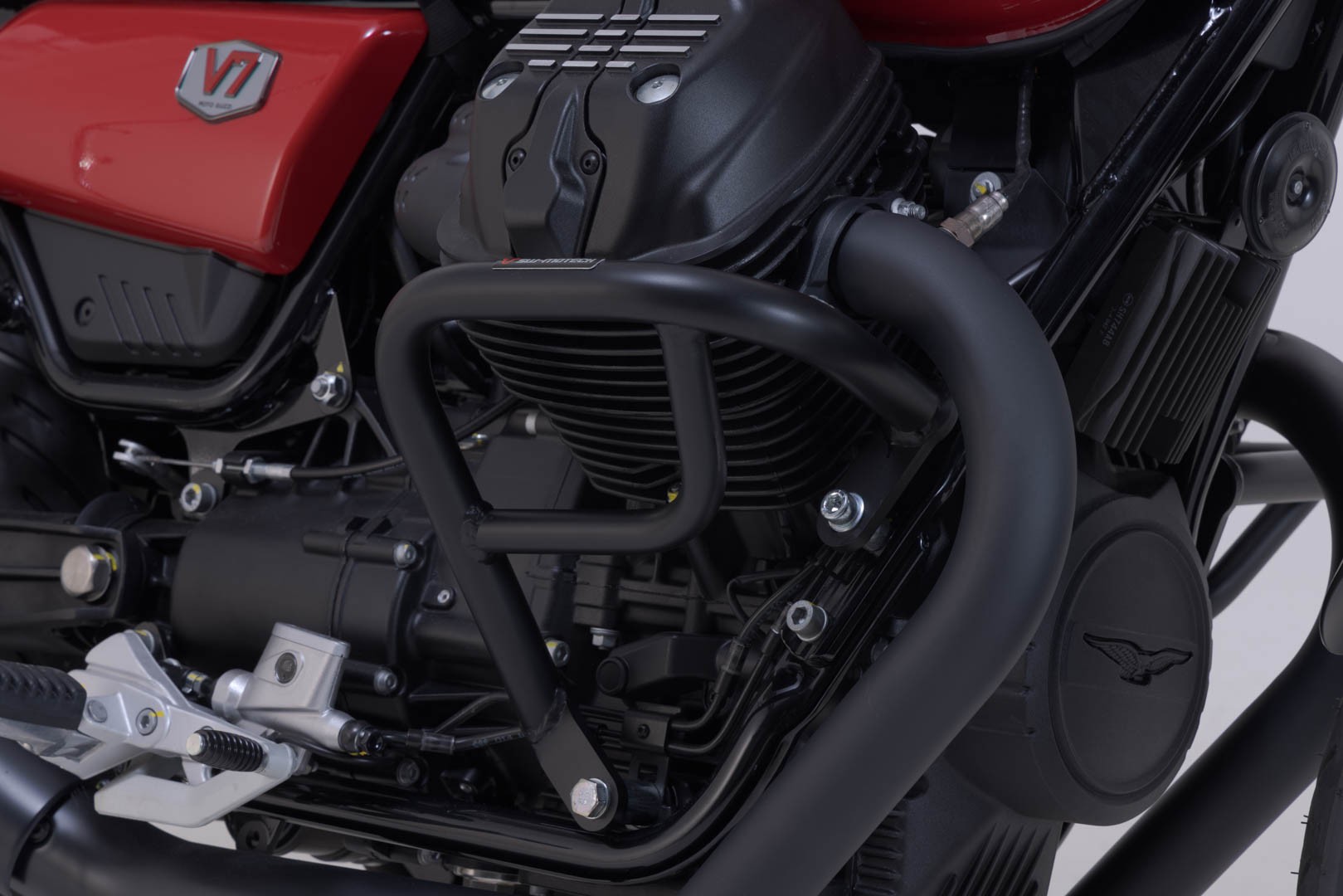 Black SW-Motech crash bar designed for Moto Guzzi V7/V9 models, featuring a sturdy metal construction and a sleek, protective design around the engine area.