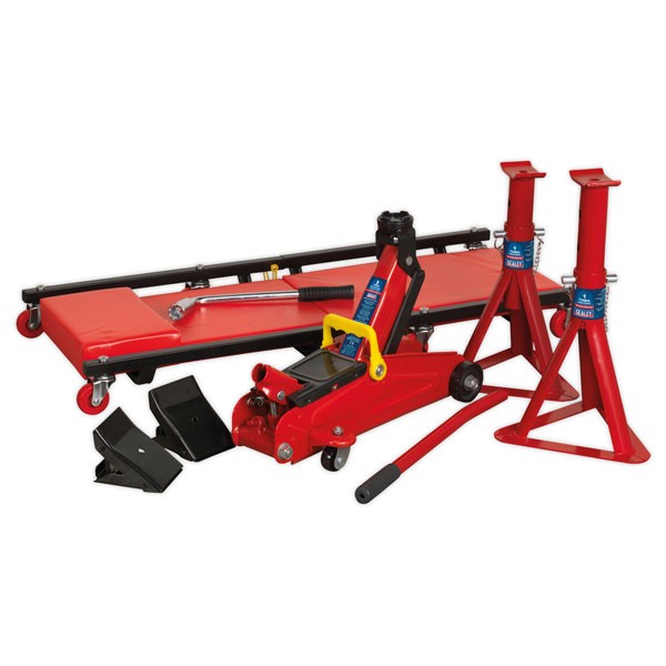 Red and black Sealey JKIT01 lifting kit includes a 2-tonne hydraulic jack, two red axle stands, a creeper with a padded surface, and various lifting accessories.