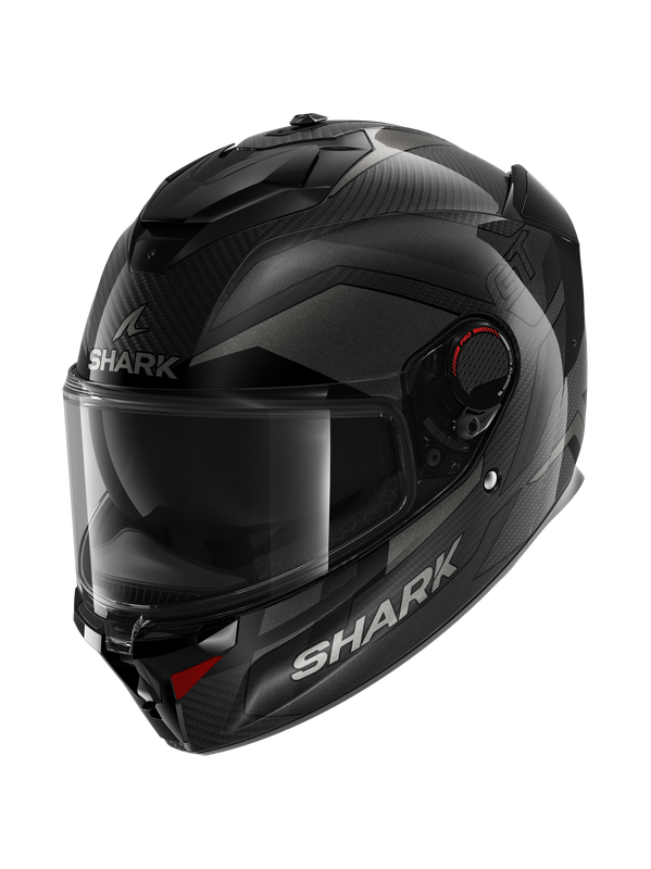 Full face helmet in black and dark grey, featuring a carbon fiber texture, clear visor, and Shark branding, designed for size M with aerodynamic contours.