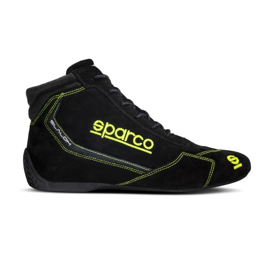 Black suede Sparco Slalom race boots with fluro yellow accents, featuring a high-top design, lace-up front, and reinforced heel for racing performance, size UK 13 / EUR 48.