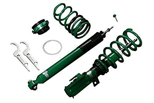 Green coilover suspension kit featuring a shock absorber, springs, mounting hardware, and adjustment tools, designed for enhanced vehicle performance.