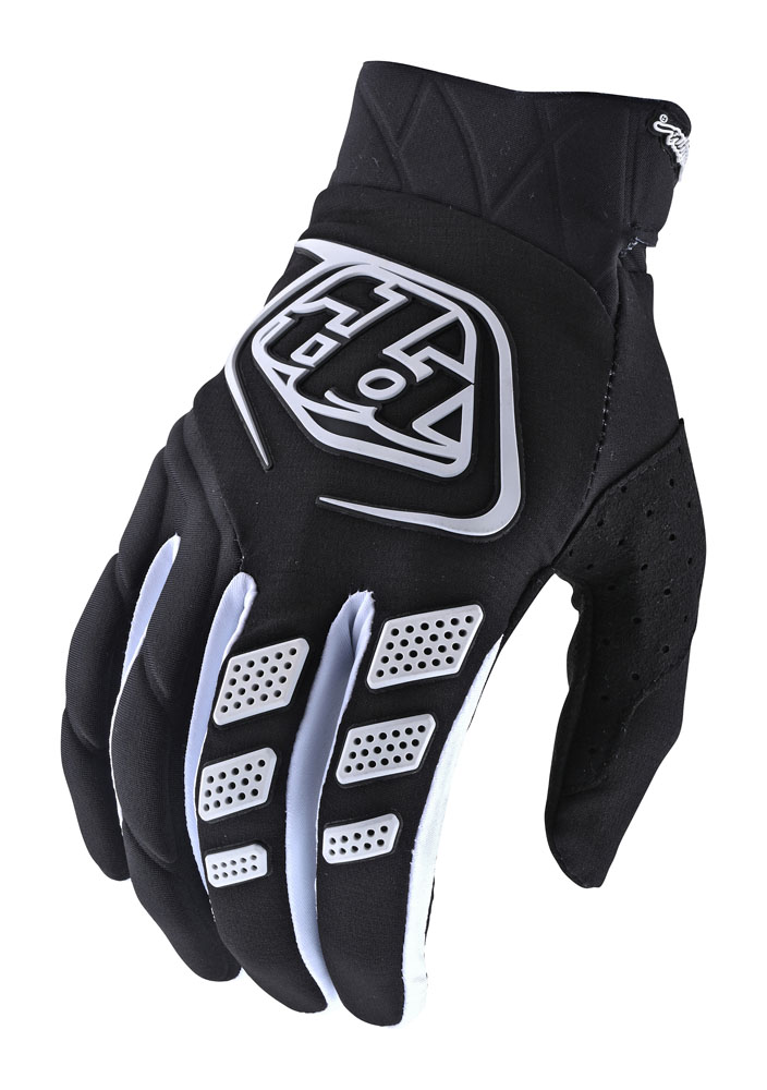 Black textile gloves featuring a white Troy Lee Designs logo, textured grip pads, and perforated sections for breathability.
