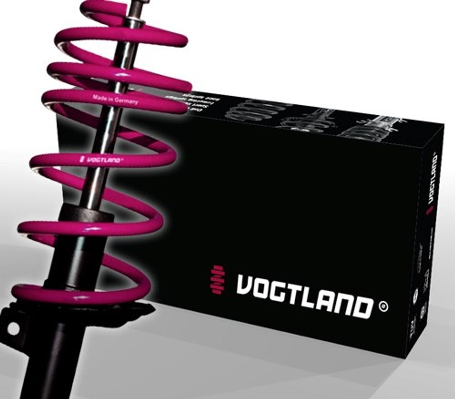 Vogtland Club Lowering Suspension Kit featuring a black shock absorber with a vibrant pink coil spring, packaged in a sleek black box with white logo and text.
