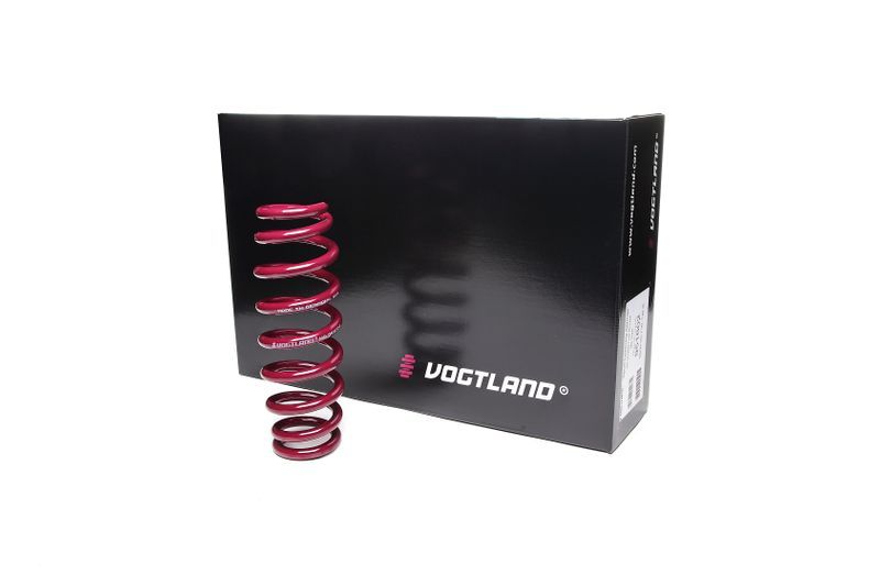 Vogtland Sport Lowering Spring in vibrant red, featuring a coiled design, positioned next to a sleek black box with white and pink branding.