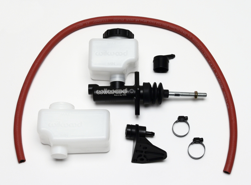 Compact remote brake master cylinder with a 1-inch bore, black metal body, two white plastic reservoirs, red rubber hose, and various fittings and clips.