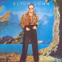 "Caribou" vinyl record cover featuring a person in a tiger-striped jacket and sunglasses against a surreal landscape backdrop.