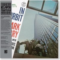 "In Orbit" vinyl record with cover art of skyscraper view and two figures, featuring bold blue and red text.