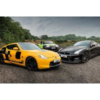 Yellow Nissan 370Z and black Nissan GTR parked on gravel with trees in background.