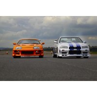 Orange and white sports cars on a racetrack, featuring bold stripes and sleek designs for a driving experience package.