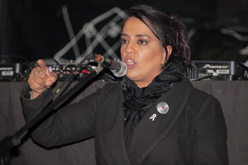 Person speaking passionately into microphone on stage