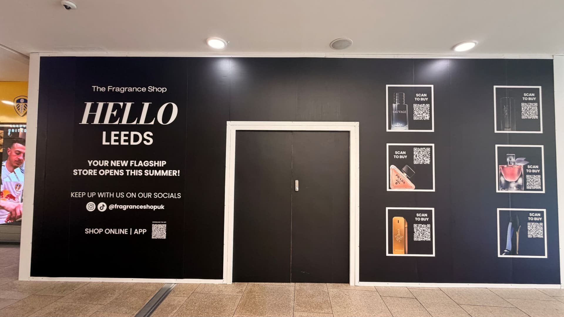 Black storefront sign announcing new fragrance shop in Leeds