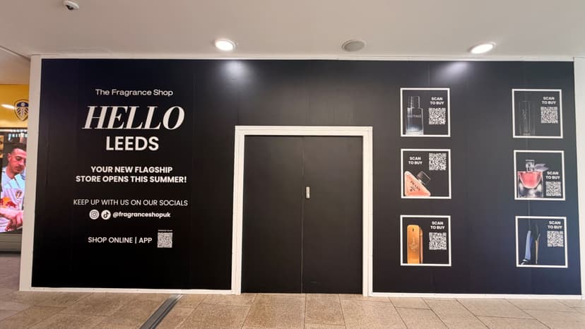 Black storefront sign announcing new fragrance shop in Leeds