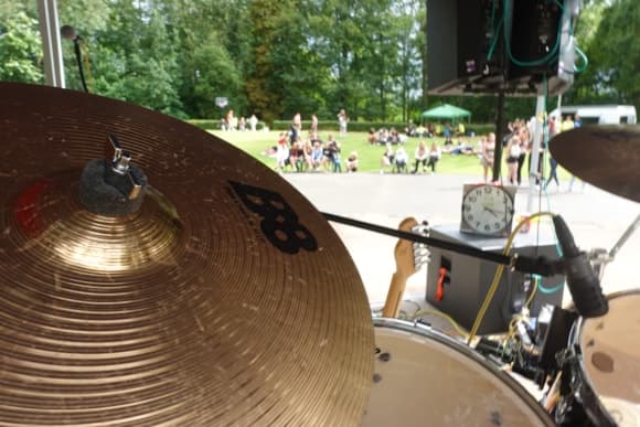 Drum set on outdoor stage with audience in park