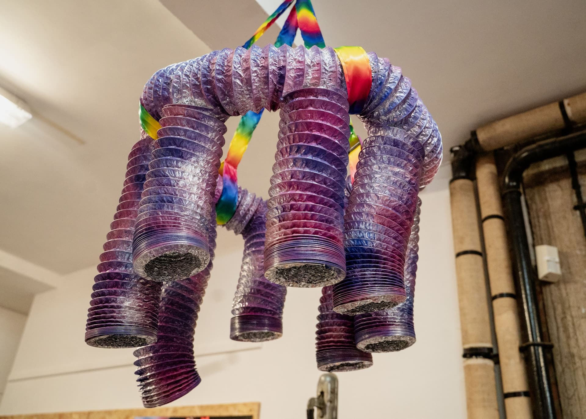 Colourful slinky chandelier hanging from a ceiling indoors