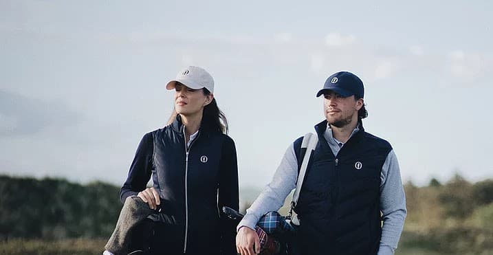 Golfers in casual attire walking on a grassy course