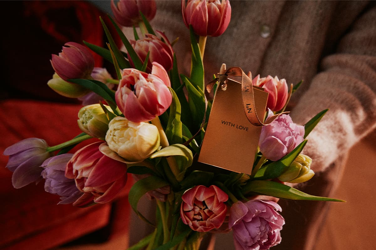 Bouquet of pink, yellow, and purple tulips with a gift tag