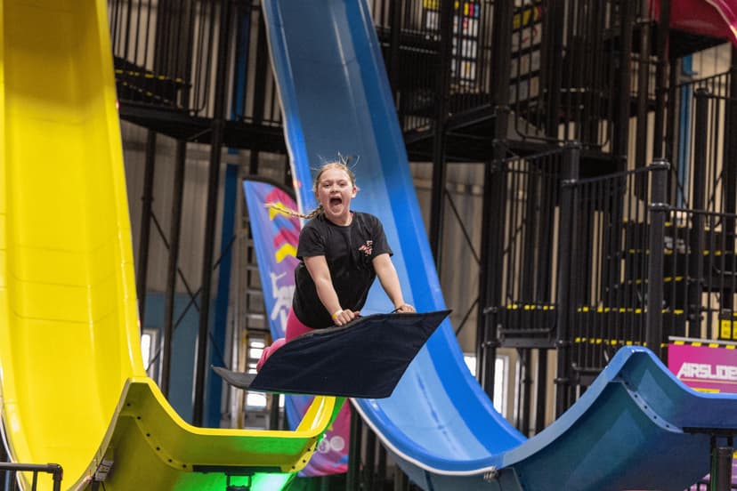 Child sliding down indoor slide with bright colors