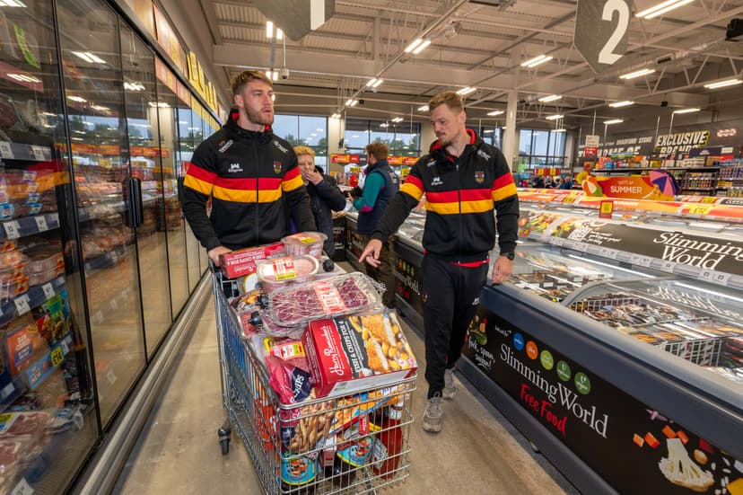 Two men in sports jackets shopping in a supermarket aisle