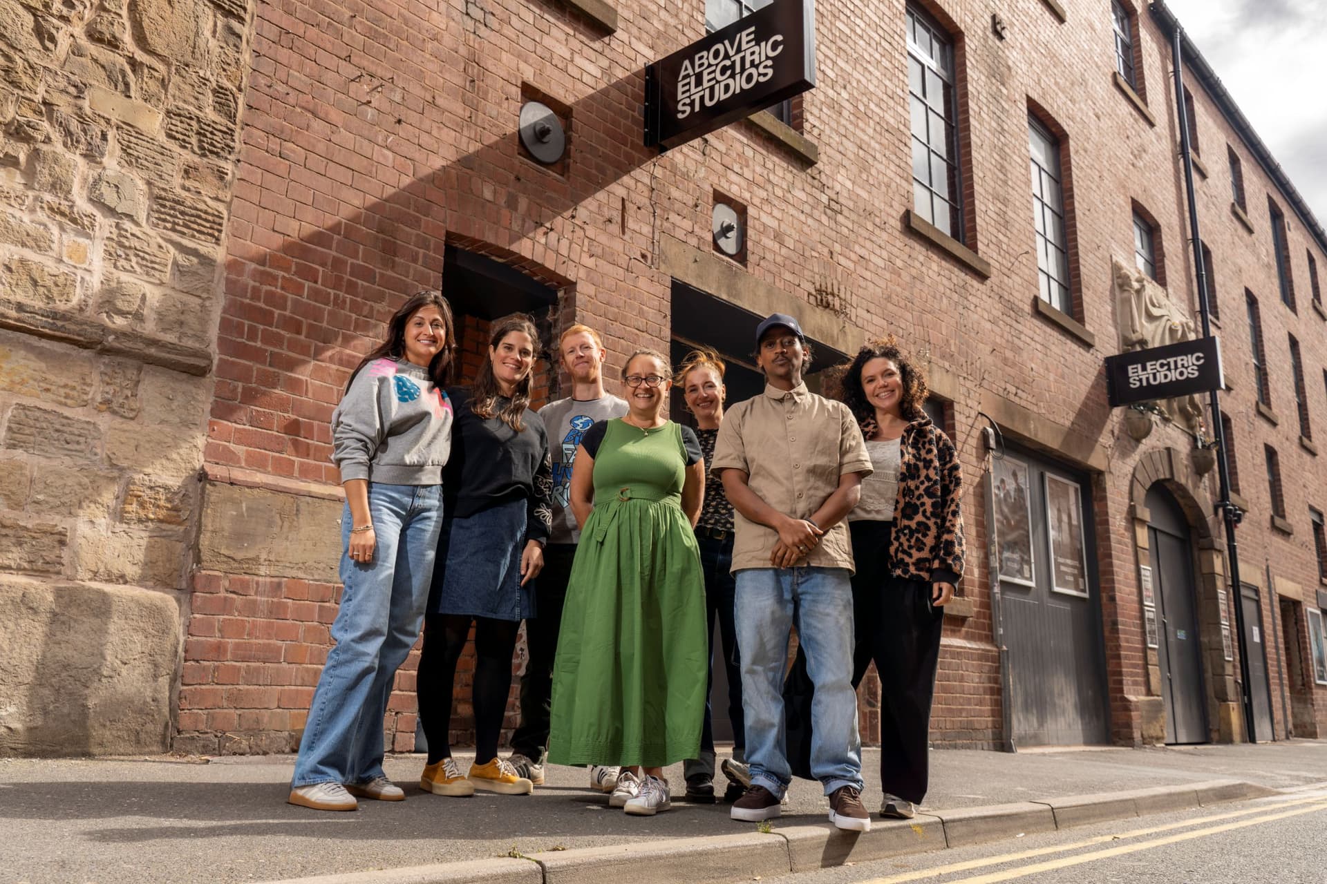Group of people smiling outside a historic brick building