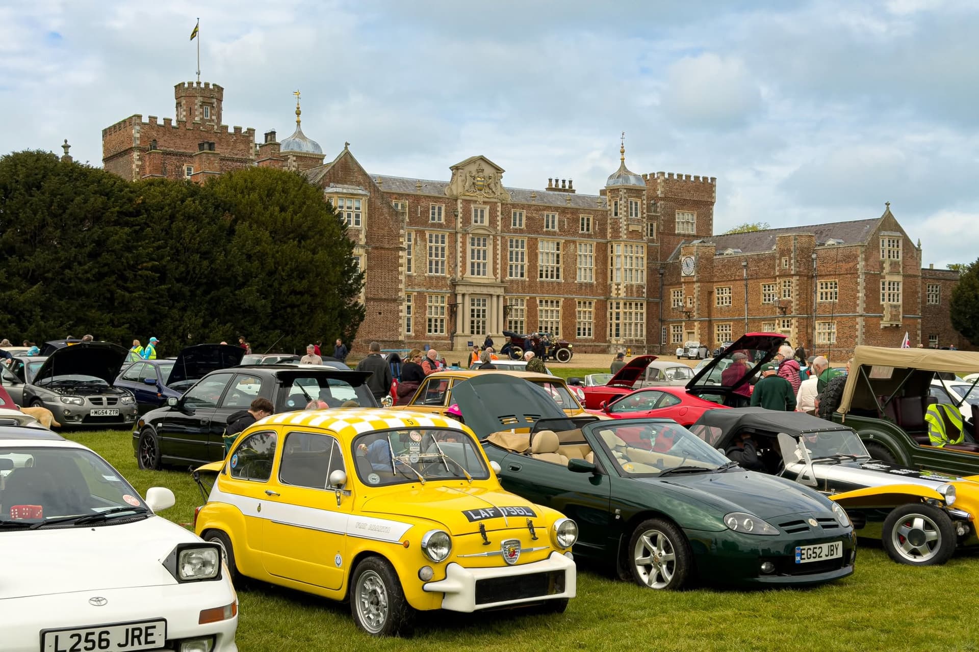 Classic car show on lawn of historic red brick mansion