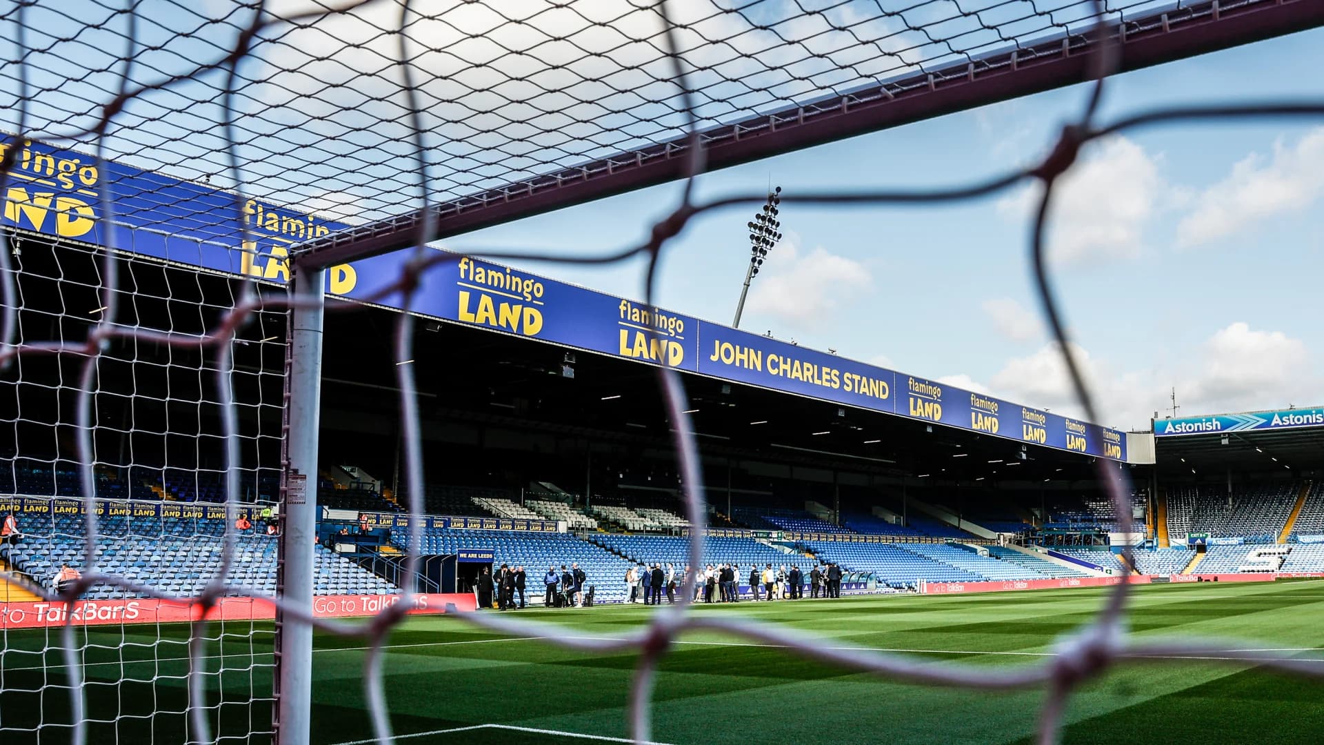 View through goal net to empty football stadium stands