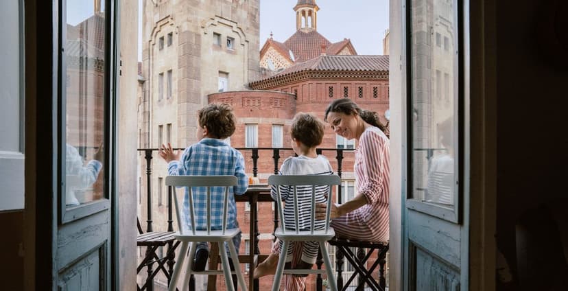 Family on balcony overlooking historic brick buildings