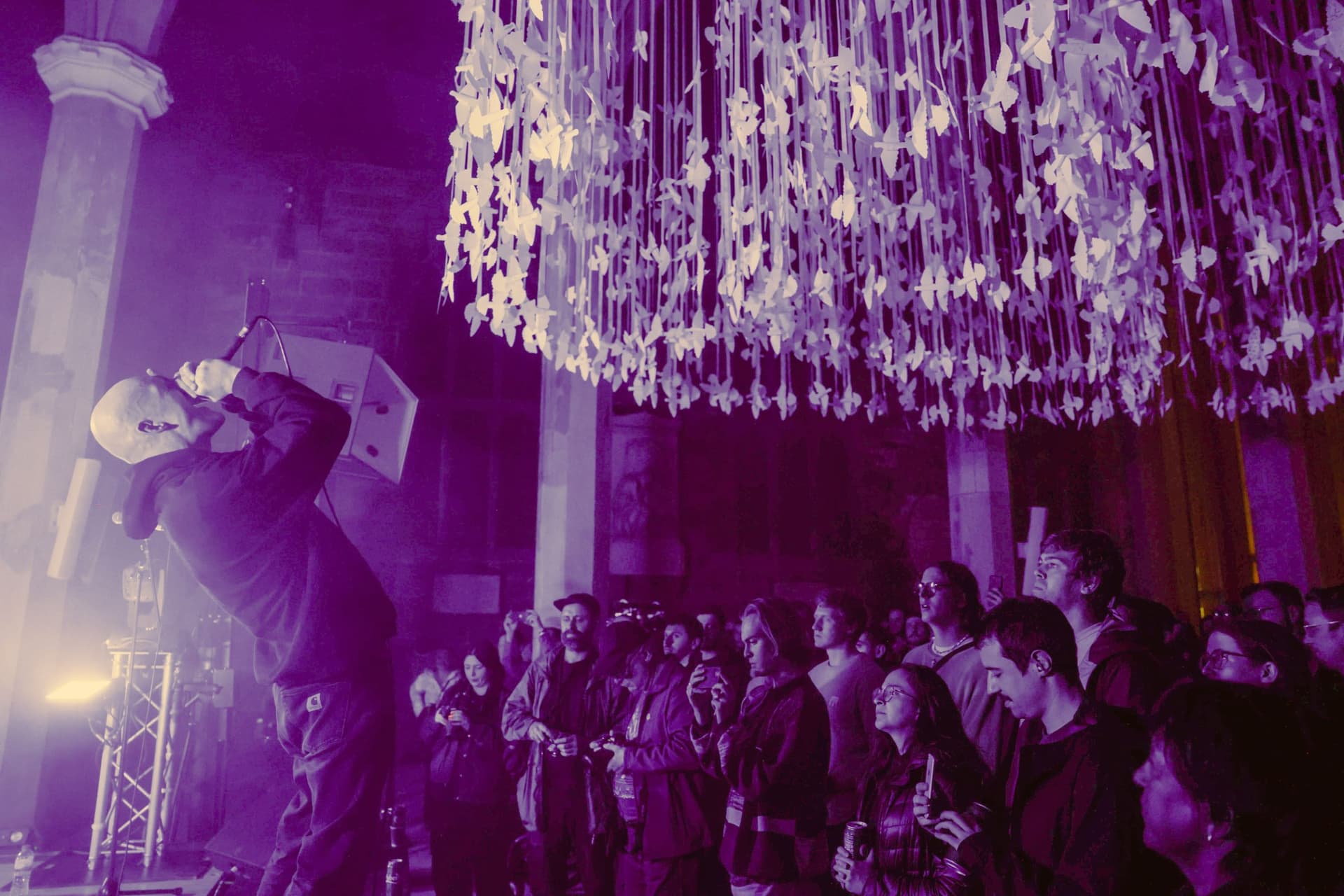Concert in historic venue with crowd and ceiling art