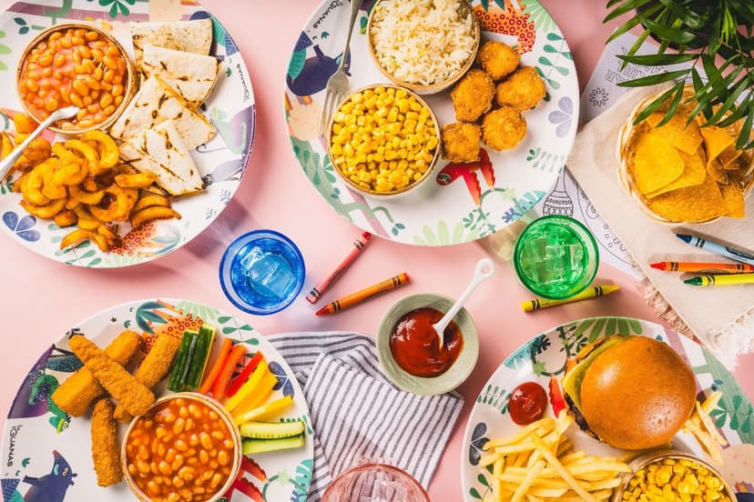 Colorful plates with various foods on a pink table