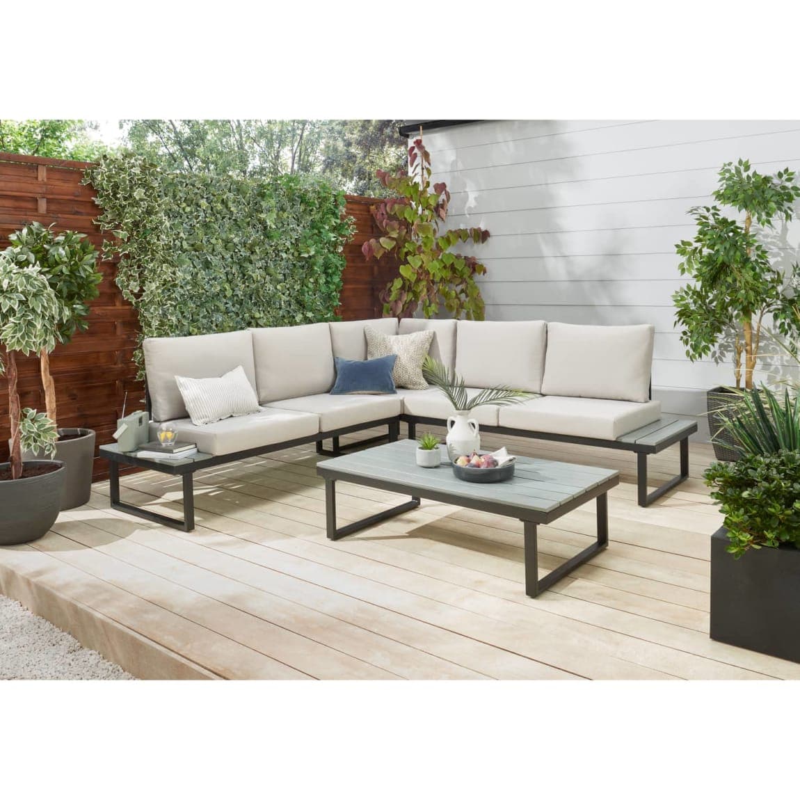 Modern patio with beige sectional sofa and green plants