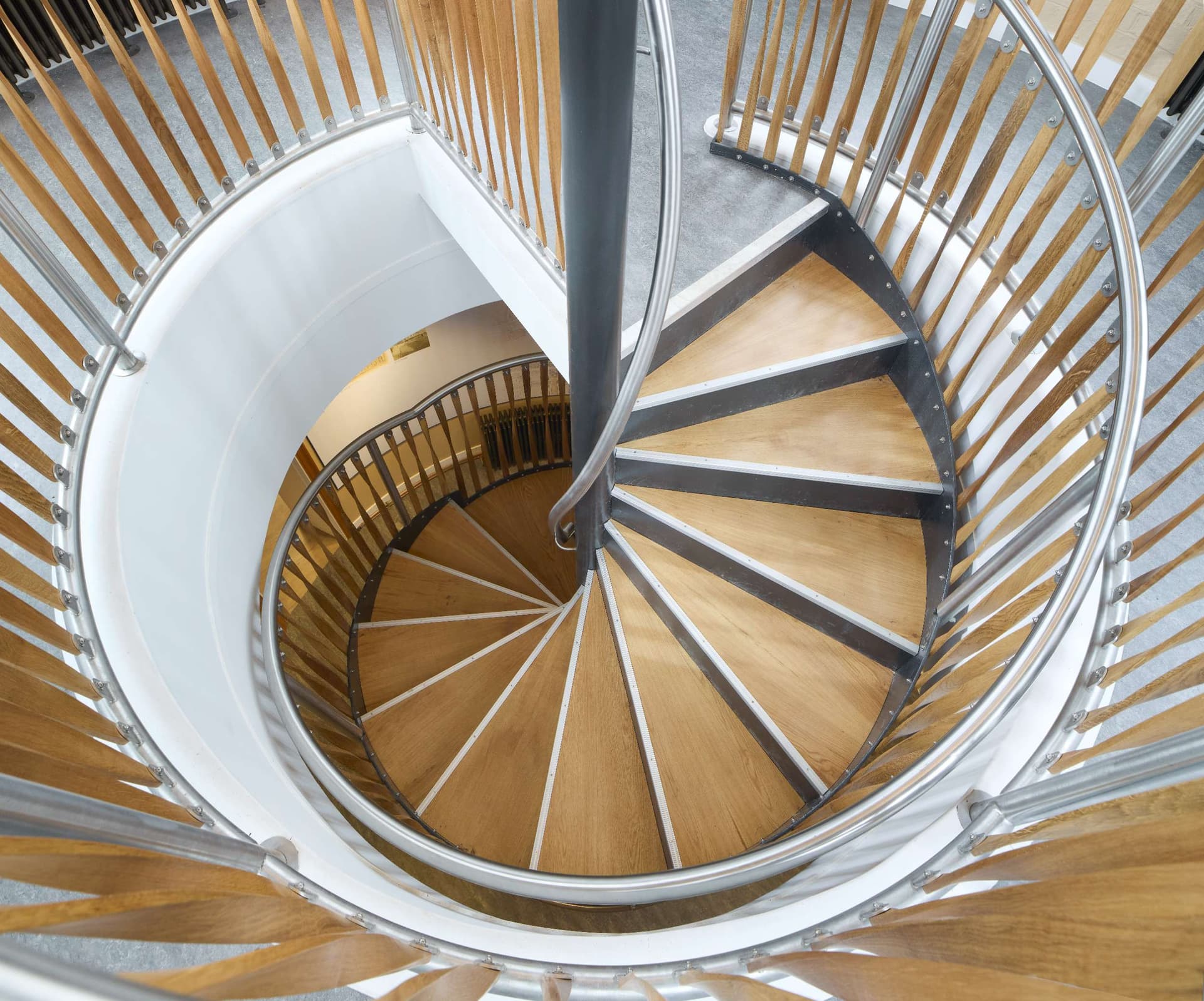 Spiral wooden staircase with sleek metal railings in modern design