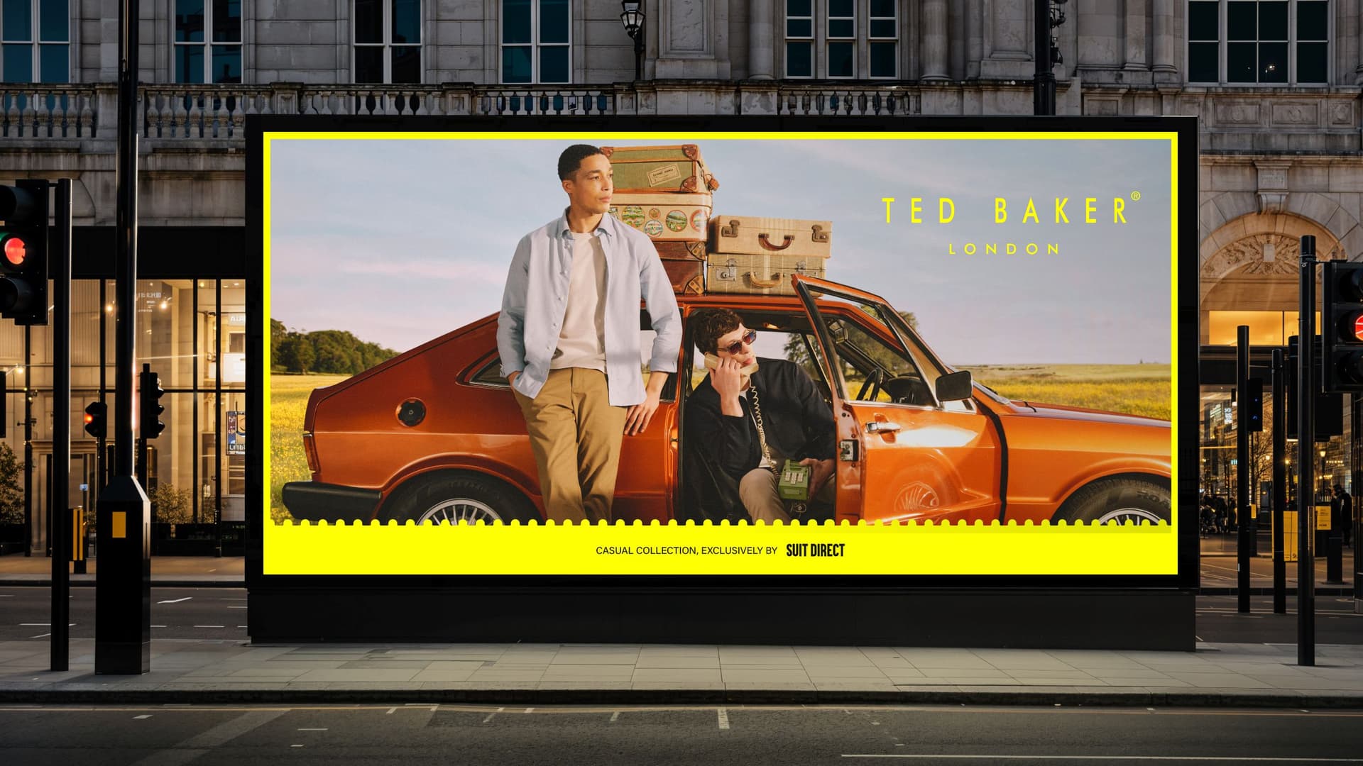 Large billboard with two men by an orange car in urban setting