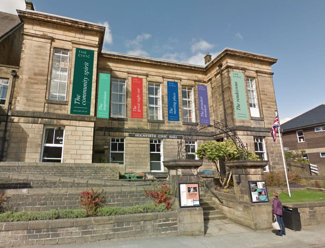 Historic stone civic hall with colourful banners and Union Jack