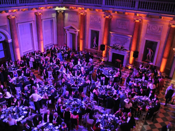 Elegant banquet hall with guests dining under purple lighting