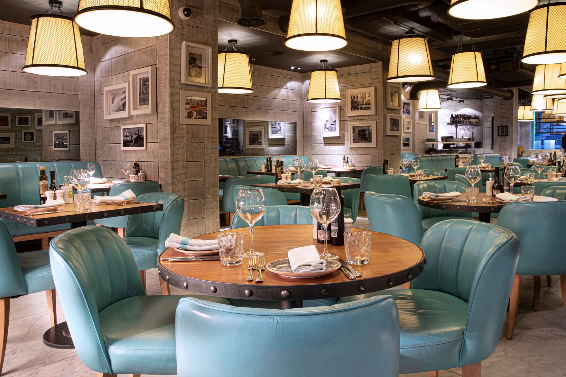 Cozy restaurant interior with teal chairs and hanging lights