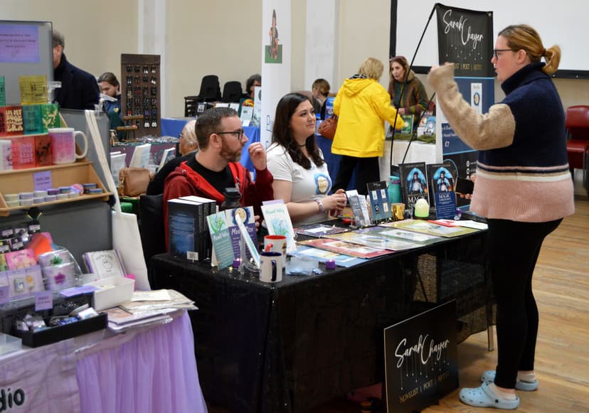 Indoor craft fair with vendors displaying handmade items