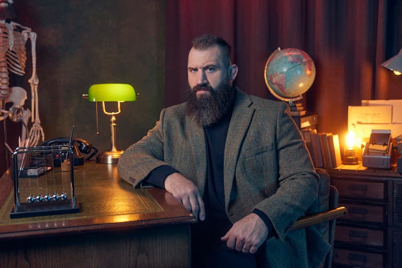 Man with beard in tweed jacket sitting at vintage desk