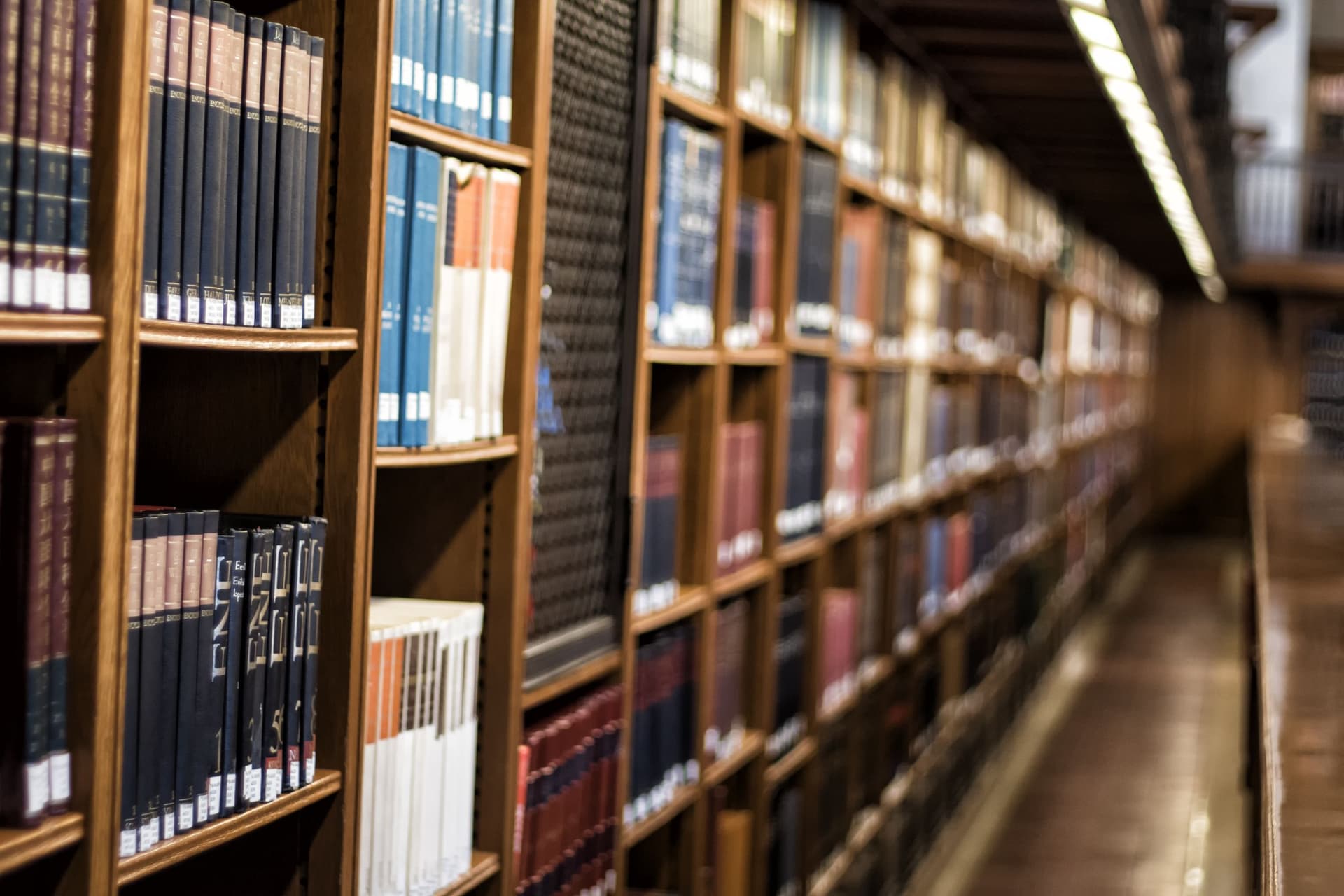 Rows of wooden bookshelves filled with colourful books in a library