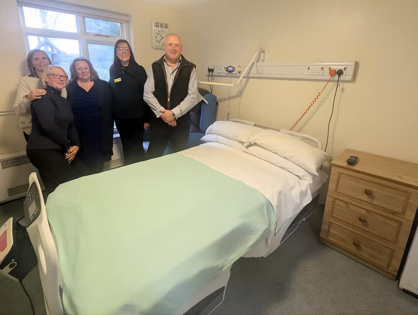 Group of five people standing in a cozy hospital room
