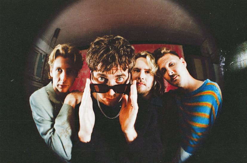 Four people posing indoors with a fisheye lens effect