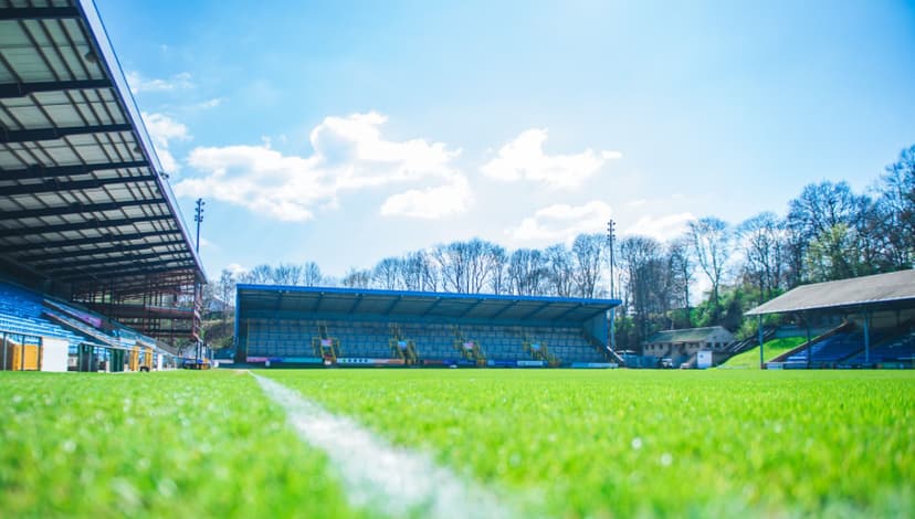 Sunny day at football stadium with empty blue seats